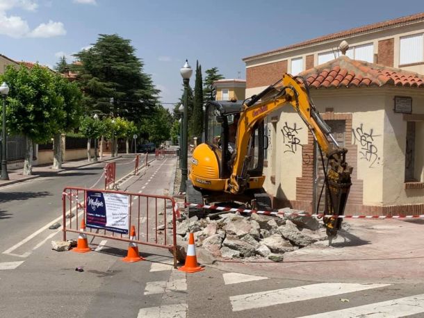 Grúa cavando la acera de la calle pública 