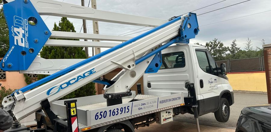 Grúa de color blanco y azul preparada para usar en la puerta de una casa 