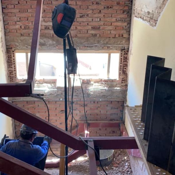 Obre dentro de un edificio trabajando en la estructura metálica de la escalera 
