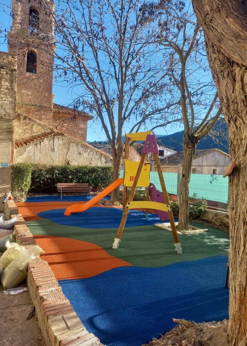 Parque infantil de colores variados en un entorno de pueblo 